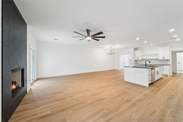 2504 W Birmingham St, Broken Arrow, OK 74011 - unfurnished living room with a sink, ceiling fan, a chandelier, a large fireplace, and recessed lighting