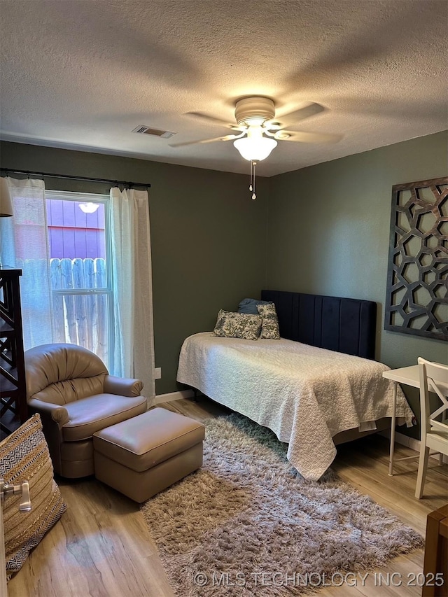 166 N Spruce Ave, Bartlesville, OK 74006 - bedroom featuring wood finished floors, a textured ceiling, and ceiling fan