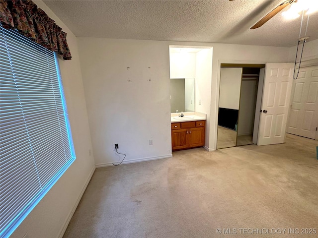 108 NW Division St, Red Oak, OK 74563 - unfurnished bedroom featuring a textured ceiling, a sink, light colored carpet, baseboards, and a closet