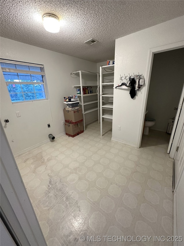 108 NW Division St, Red Oak, OK 74563 - laundry area with a textured ceiling, light flooring, and baseboards
