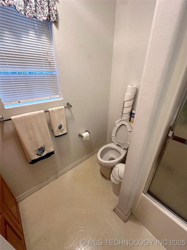 108 NW Division St, Red Oak, OK 74563 - bathroom with toilet, a shower with shower door, and baseboards