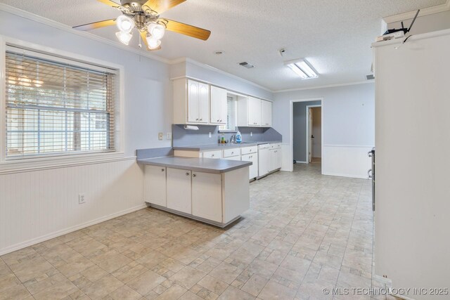 901 Christy, Calera, OK 74730 - kitchen with a peninsula, white cabinets, a textured ceiling, baseboards, and crown molding