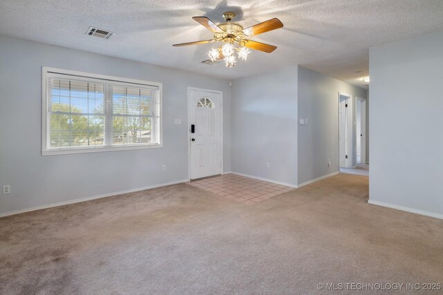 901 Christy, Calera, OK 74730 - carpeted foyer featuring ceiling fan, baseboards, a textured ceiling, and tile patterned floors