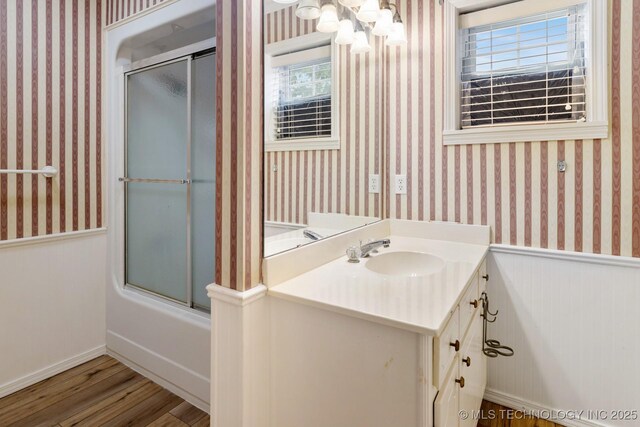 901 Christy, Calera, OK 74730 - bathroom with wood finished floors, vanity, a chandelier, a wainscoted wall, and wallpapered walls