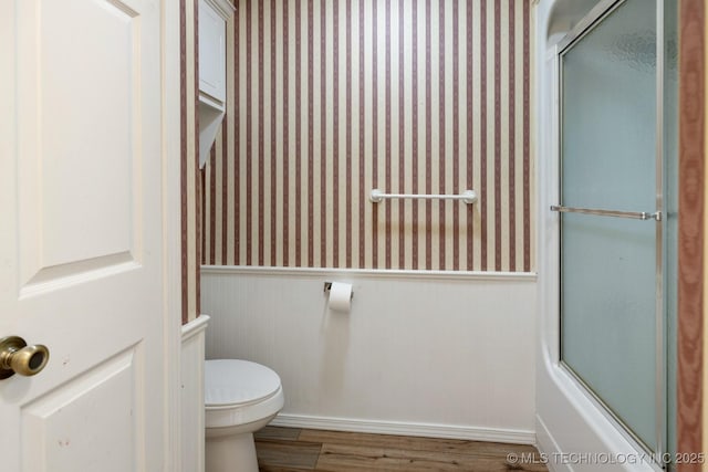 901 Christy, Calera, OK 74730 - full bathroom featuring wainscoting, wallpapered walls, wood finished floors, toilet, and enclosed tub / shower combo