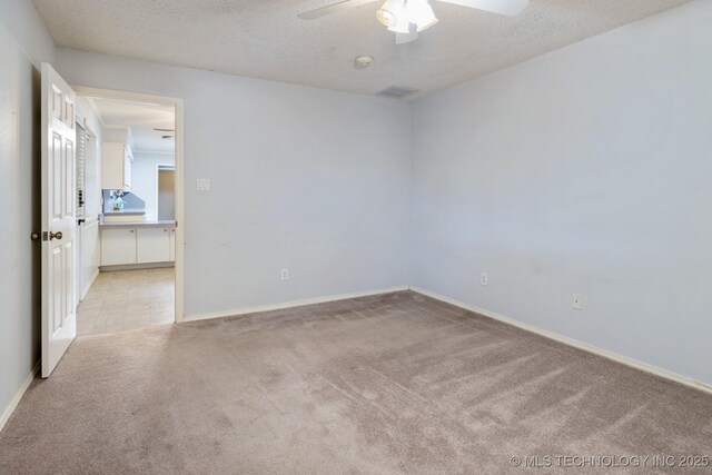 901 Christy, Calera, OK 74730 - spare room with light colored carpet, a ceiling fan, baseboards, and a textured ceiling