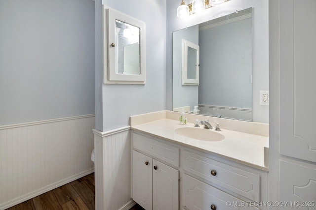 901 Christy, Calera, OK 74730 - bathroom with vanity, toilet, wood finished floors, and a wainscoted wall