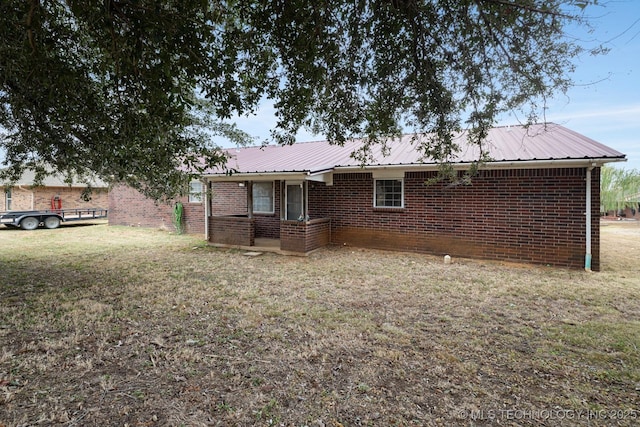 901 Christy, Calera, OK 74730 - rear view of house featuring brick siding, metal roof, and a lawn