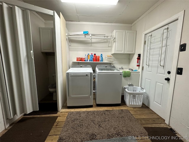 661 12th NW, Ardmore, OK 73401 - washroom featuring separate washer and dryer, light wood finished floors, cabinet space, and ornamental molding