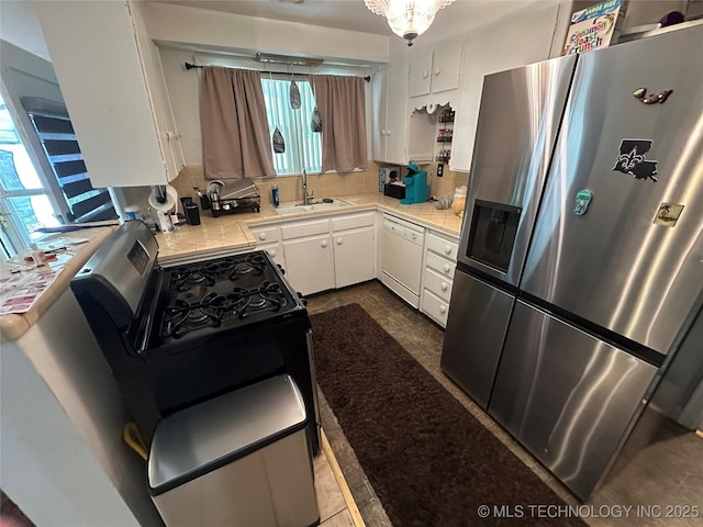 661 12th NW, Ardmore, OK 73401 - kitchen featuring stainless steel appliances, a sink, white cabinets, and backsplash