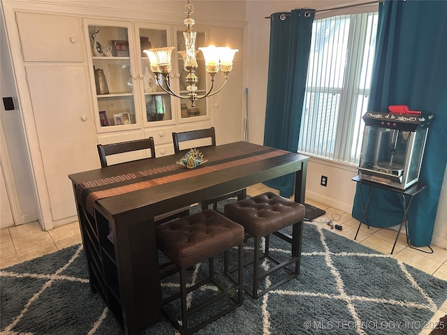 661 12th NW, Ardmore, OK 73401 - dining area featuring light tile patterned floors, a chandelier, and baseboards
