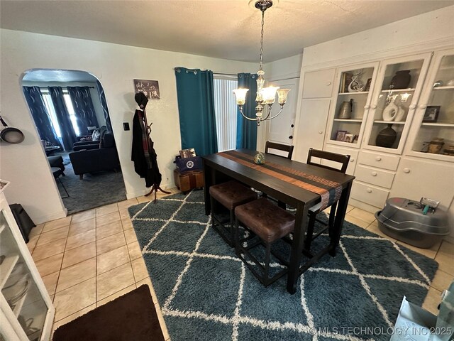 661 12th NW, Ardmore, OK 73401 - dining area with a chandelier, light tile patterned floors, arched walkways, and a textured ceiling