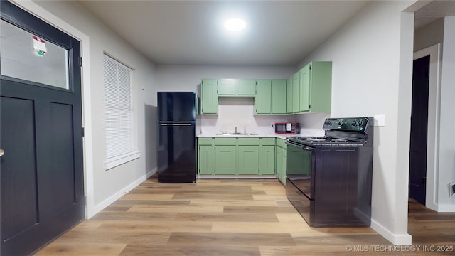 420 W State, Stratford, OK 74872 - kitchen with black appliances, green cabinets, a sink, baseboards, and light wood-type flooring