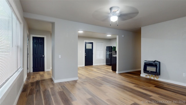 420 W State, Stratford, OK 74872 - unfurnished living room featuring heating unit, light wood-type flooring, a ceiling fan, and baseboards