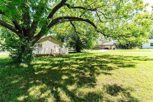 609 E Tejon Ave, Bristow, OK 74010 - view of green lawn with a wooden deck