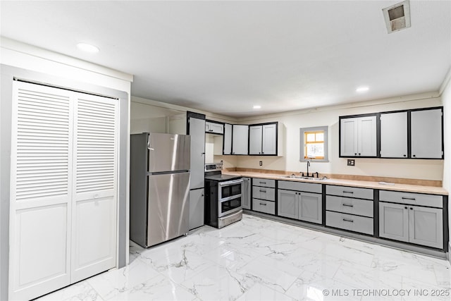302 E 8th Ave, Bristow, OK 74010 - kitchen with stainless steel appliances, a sink, gray cabinetry, light countertops, and recessed lighting
