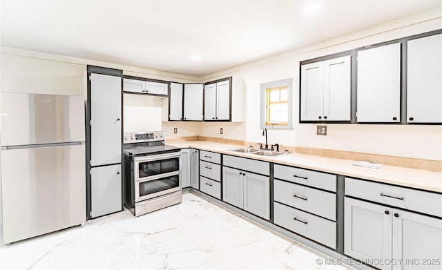 302 E 8th Ave, Bristow, OK 74010 - kitchen with stainless steel appliances, a sink, light marble finish floors, light countertops, and recessed lighting