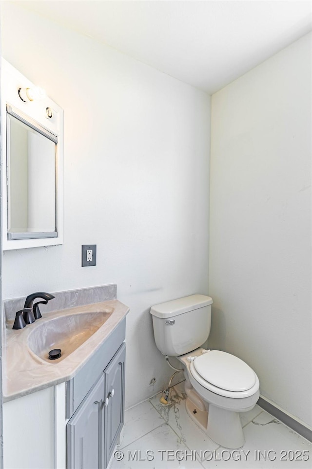 302 E 8th Ave, Bristow, OK 74010 - bathroom featuring marble look tiles, toilet, and vanity