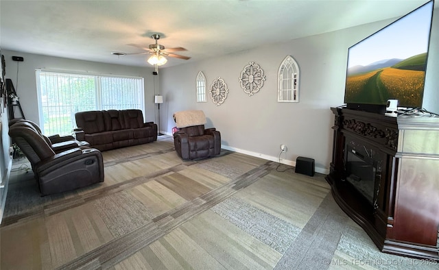 912 Elm, Ardmore, OK 73401 - living area featuring a ceiling fan, a glass covered fireplace, baseboards, and wood finished floors