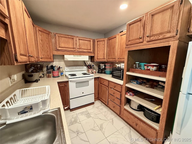 912 Elm, Ardmore, OK 73401 - kitchen featuring white appliances, light marble finish floors, under cabinet range hood, light countertops, and brown cabinets