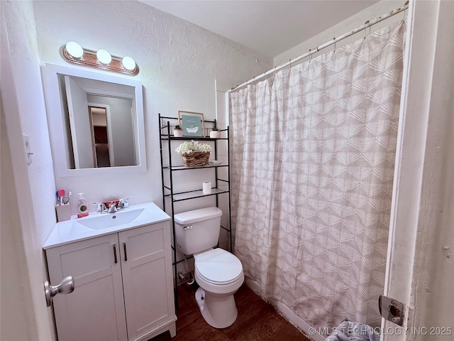 912 Elm, Ardmore, OK 73401 - full bath featuring toilet, vanity, wood finished floors, a textured wall, and a shower with shower curtain