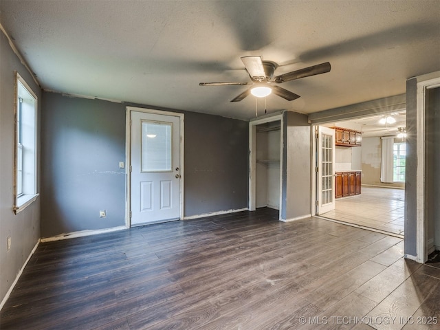 12641 S 281st E Ave, Coweta, OK 74429 - unfurnished living room with wood finished floors, a textured ceiling, a ceiling fan, and baseboards