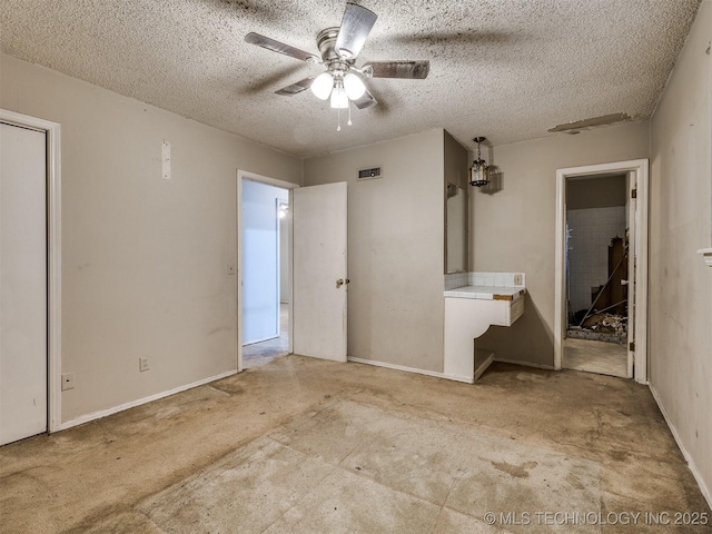 12641 S 281st E Ave, Coweta, OK 74429 - unfurnished bedroom featuring a textured ceiling, baseboards, and a ceiling fan
