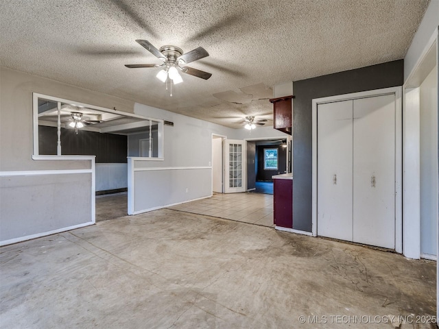 12641 S 281st E Ave, Coweta, OK 74429 - unfurnished bedroom with a textured ceiling, concrete floors, ceiling fan, and baseboards
