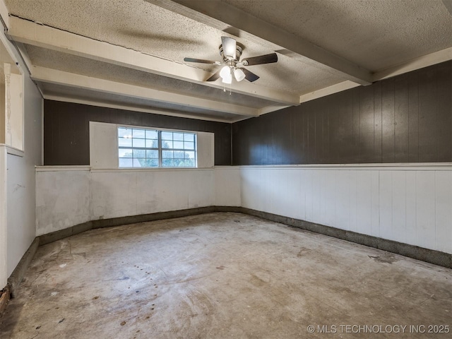 12641 S 281st E Ave, Coweta, OK 74429 - empty room featuring concrete floors, a textured ceiling, ceiling fan, wood walls, and beam ceiling