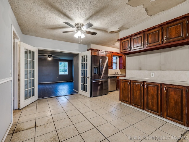 12641 S 281st E Ave, Coweta, OK 74429 - kitchen featuring appliances with stainless steel finishes, light tile patterned flooring, light countertops, ceiling fan, and a textured ceiling