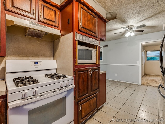 12641 S 281st E Ave, Coweta, OK 74429 - kitchen with white appliances, under cabinet range hood, light tile patterned flooring, a ceiling fan, and a textured ceiling