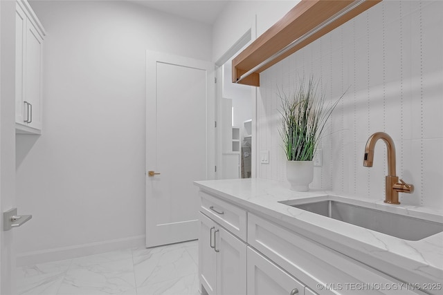 1227 N 71st Pl, Broken Arrow, OK 74014 - kitchen featuring a sink, white cabinets, light marble finish flooring, light stone counters, and baseboards