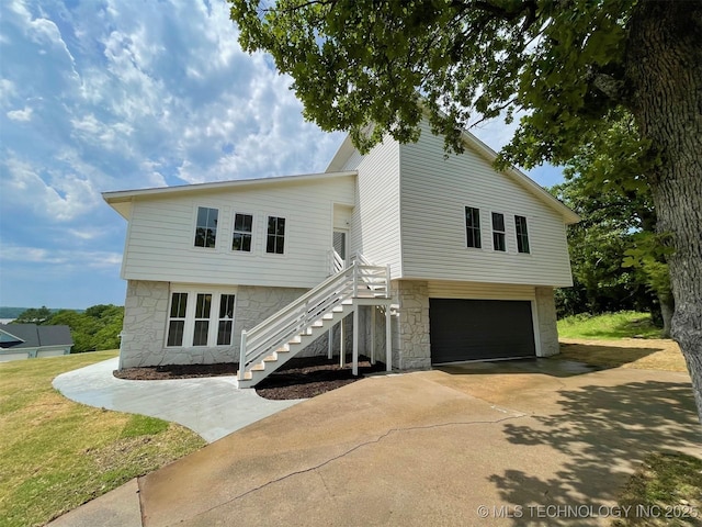 228 W Hickory Dr, Sand Springs, OK 74063 - view of front of home featuring stone siding, a garage, stairway, and concrete driveway