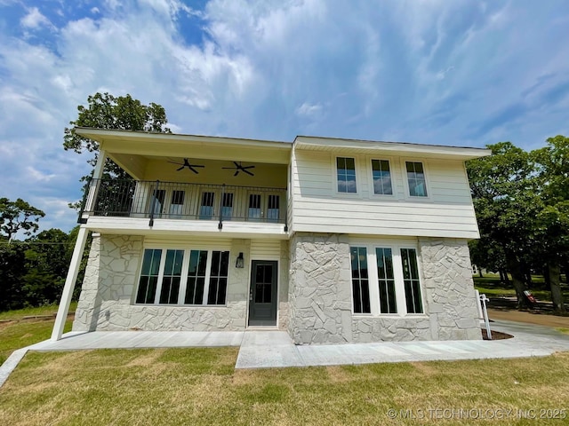 228 W Hickory Dr, Sand Springs, OK 74063 - back of house with stone siding, a balcony, a ceiling fan, and a lawn