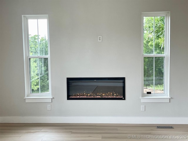 228 W Hickory Dr, Sand Springs, OK 74063 - detailed view of a glass covered fireplace, baseboards, and wood finished floors
