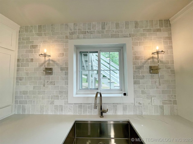 228 W Hickory Dr, Sand Springs, OK 74063 - kitchen view of a sink, backsplash, light countertops, and white cabinetry