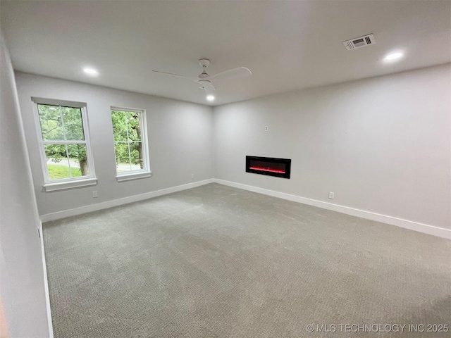 228 W Hickory Dr, Sand Springs, OK 74063 - carpeted spare room with a ceiling fan, recessed lighting, baseboards, and a glass covered fireplace
