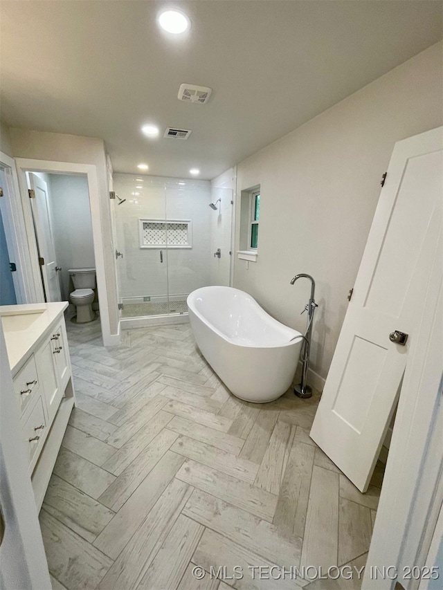 228 W Hickory Dr, Sand Springs, OK 74063 - bathroom featuring a shower stall, a freestanding bath, vanity, recessed lighting, and toilet