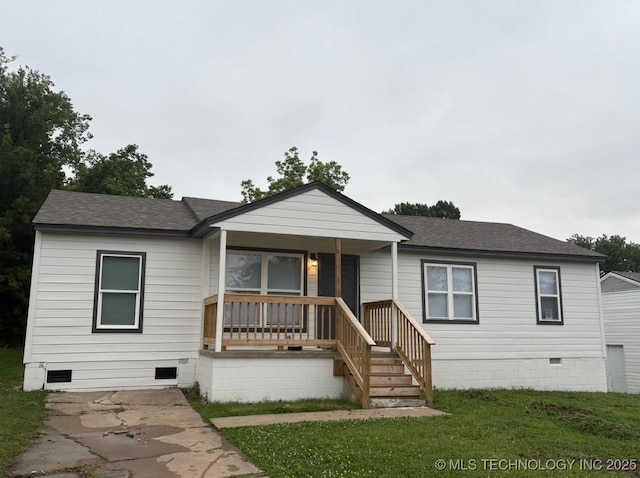 6837 E King Pl, Tulsa, OK 74115 - view of front of home with crawl space, covered porch, roof with shingles, and a front lawn
