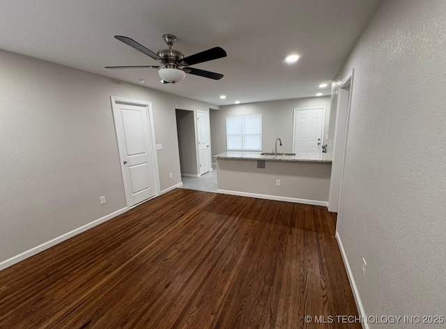 6837 E King Pl, Tulsa, OK 74115 - unfurnished living room with dark wood-style flooring, baseboards, ceiling fan, a sink, and recessed lighting