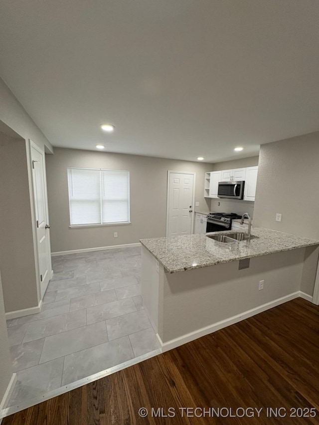 6837 E King Pl, Tulsa, OK 74115 - kitchen featuring stainless steel appliances, light stone countertops, a peninsula, white cabinets, and a sink