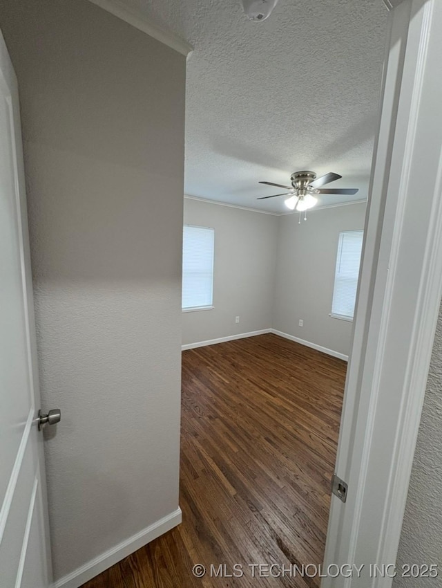 6837 E King Pl, Tulsa, OK 74115 - empty room with plenty of natural light, a ceiling fan, dark wood-type flooring, baseboards, and a textured ceiling