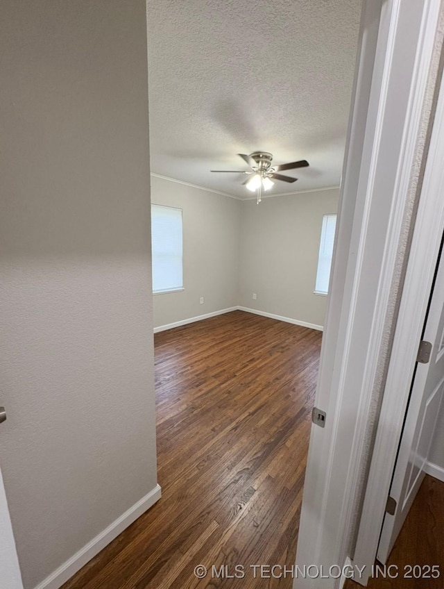6837 E King Pl, Tulsa, OK 74115 - unfurnished room with ceiling fan, dark wood finished floors, a textured ceiling, and baseboards