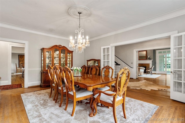 319 E 21st St, Tulsa, OK 74114 - dining area featuring french doors, crown molding, a chandelier, and wood finished floors