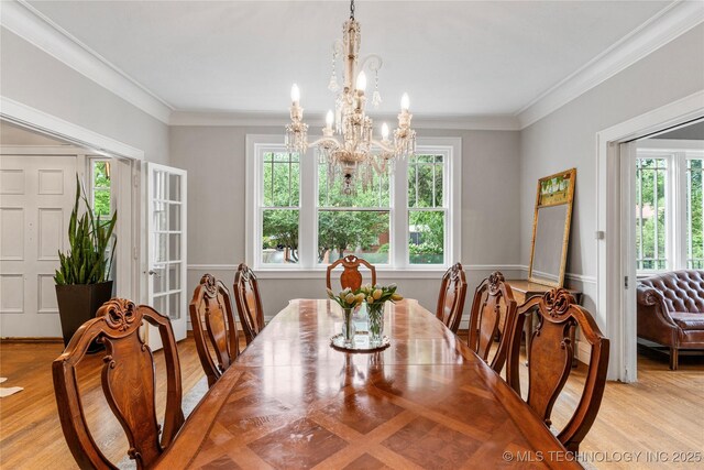 319 E 21st St, Tulsa, OK 74114 - dining area featuring healthy amount of natural light, a chandelier, light wood finished floors, and ornamental molding