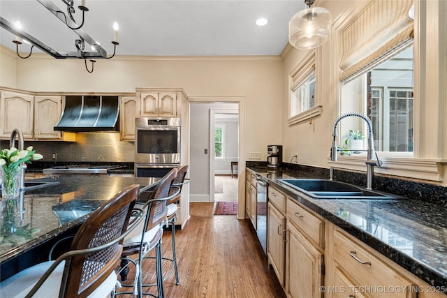 319 E 21st St, Tulsa, OK 74114 - kitchen with custom exhaust hood, a sink, light brown cabinetry, dark wood finished floors, and stainless steel appliances