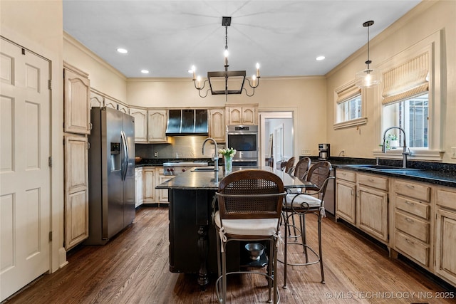 319 E 21st St, Tulsa, OK 74114 - kitchen featuring stainless steel appliances, a sink, light brown cabinetry, an island with sink, and tasteful backsplash