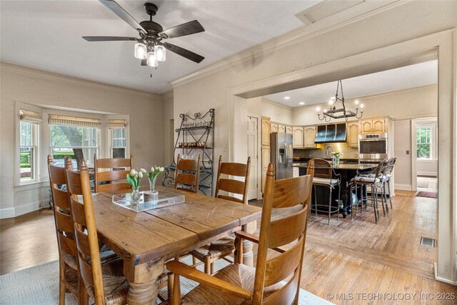 319 E 21st St, Tulsa, OK 74114 - dining space featuring ornamental molding, plenty of natural light, light wood-style floors, a chandelier, and a ceiling fan