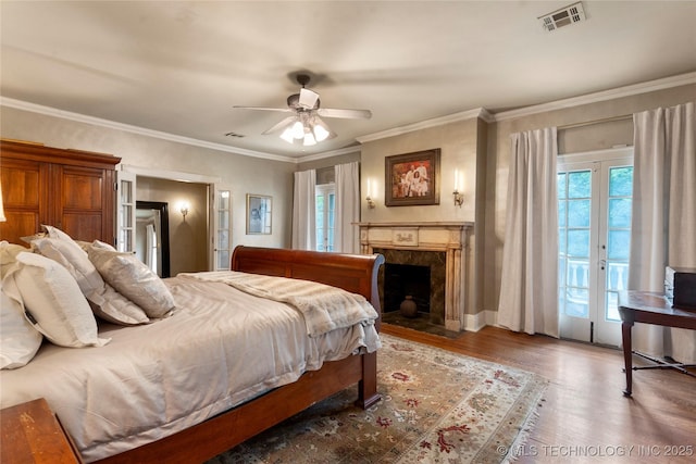 319 E 21st St, Tulsa, OK 74114 - bedroom featuring access to exterior, multiple windows, wood finished floors, a premium fireplace, and ornamental molding