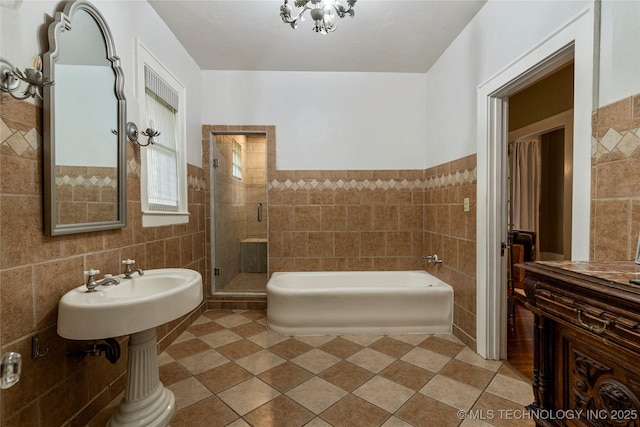 319 E 21st St, Tulsa, OK 74114 - full bathroom with tile walls, a bath, a shower stall, tile patterned floors, and a wainscoted wall